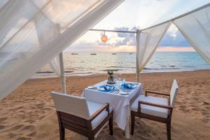 Tisch auf dem Strand im La Flora Khao Lak mit Blick auf das Meer.