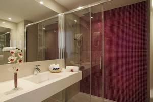 Badezimmer im Argos Hotel mit roten Fliesen und einem Spiegel.