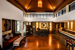 Innenansicht des Eingangsbereichs des La Flora Khao Lak Hotels mit Holzboden und Möbeln.