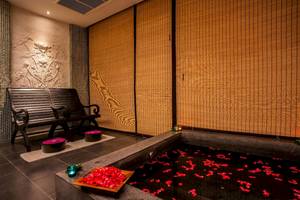 Wellnessbereich des La Flora Khao Lak Hotels mit einem großen Becken voller roter Rosenblätter.