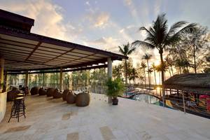 Außenbereich des Haven Khao Lak Hotels bei Sonnenuntergang mit Blick auf den Pool und den Strand.