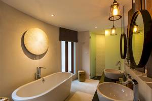 Badezimmer im Bangsak Village Hotel mit Badewanne, Waschbecken und Spiegeln.