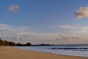 Strand des Bangsak Village Hotels mit blauem Himmel und leichten Wellen im Wasser