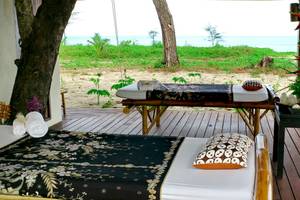 Massageliegen auf der Terrasse des Bangsak Village mit Blick auf das Meer.