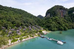Luftaufnahme der TreeHouse Villas Koh Yao mit vielen Hütten am Strand.