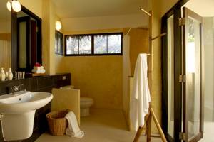 Badezimmer im Haadson Resort mit Waschbecken, Spiegel, Toilette und Dusche.