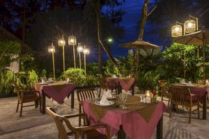 Außenbereich des Haadson Resorts Restaurant bei Nacht mit gedeckten Tischen und tropischer Umgebung.