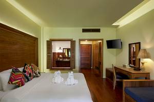 Hotelzimmer im Khaolak Paradise Resort mit zwei weißen Handtüchern auf dem Bett und einem Fernseher an der Wand.