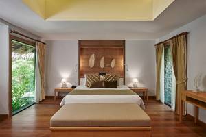 Innenansicht eines Zimmers im Khaolak Paradise Resort mit Doppelbett, Nachttischen und Fenstern.