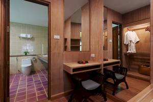 Badezimmer des Khaolak Paradise Resort mit Holzwänden, einem Toilettensitz, Waschbecken und Spiegeln.