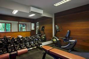 Fitnessraum im Khaolak Paradise Resort mit diversen Trainingsgeräten und Holzwänden.