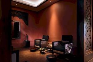 Spa-Raum im Santiburi Koh Samui Hotel mit zwei Sesseln, Töpfen und einem Spiegel.