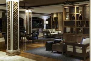 Lobby des Santiburi Koh Samui Hotels mit Holzmöbeln, Sofas, Holzsäulen und Deckenventilatoren.