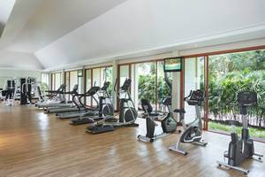 Fitnesscenter im Santiburi Koh Samui Hotel mit vielen Trainingsgeräten und Panoramafenstern.