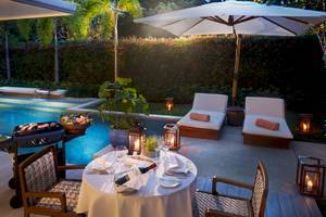 Poolseite-Dinnerbereich im Santiburi Koh Samui mit Tisch, Grill und Lounge-Möbeln.