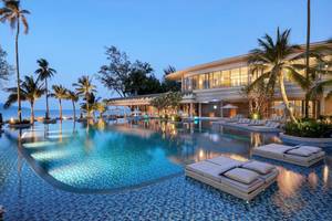 Außenpool mit Liegen und Palmen im Meliá Koh Samui Hotel bei Nacht
