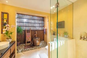 Badezimmer im Buri Rasa Village Samui mit Regendusche und Pflanzen.