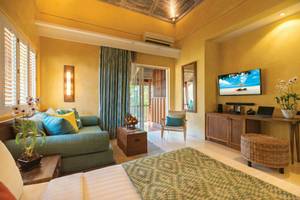 Hotelzimmer im Buri Rasa Village Samui mit einem Bett, einem Fernseher, einer Couch und einem Tisch