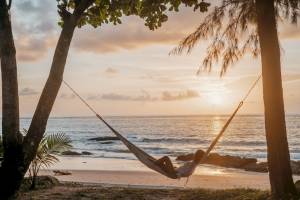 Frau auf einer Hängematte am Strand bei Sonnenuntergang, Khao Lak Merlin Resort