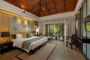 Hotelzimmer mit Bett, Lampen und Balkon im Khao Lak Merlin Resort.