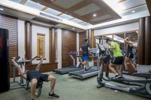Fitnessstudio im Khao Lak Merlin Resort mit Personen, die auf Laufbändern trainieren.