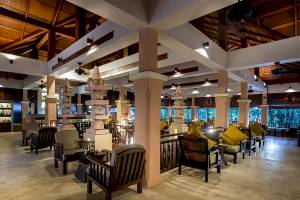 Loungebereich des Khao Lak Merlin Resorts mit Holzmöbeln und hohen Decken.