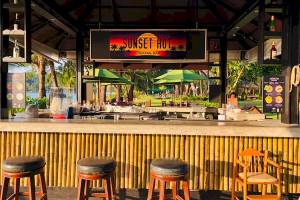 Cocktailbar im Khao Lak Merlin Resort mit Sonnenuntergangs-Thema und grünen Sonnenschirmen.