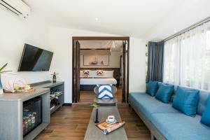 Friedrich Villa: Wohnzimmer mit Sofa, Fernseher, Tisch und offenem Schlafzimmer