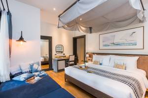 Schlafzimmer im Peace Resort mit zwei Betten, Nachttischen, Lampe und Gemälde an der Wand.