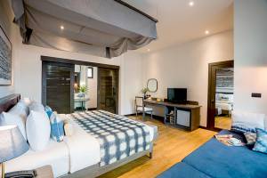 Schlafzimmer im Peace Resort mit einem großen Bett, einem Schreibtisch und einer Fernseher.