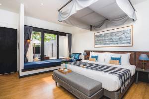 Schlafzimmer im Peace Resort mit einem Bett, Fenster und Sonnenlicht.
