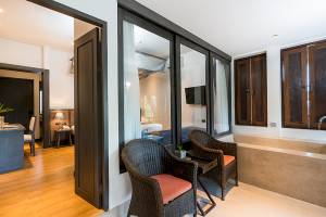 Innenansicht des Schlafzimmers im Peace Resort mit Bett, Fernseher und Badewanne.