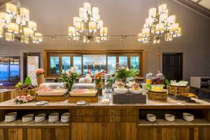 Frühstücksbuffet im Peace Resort mit verschiedenen Speisen und Getränken, gedeckten Tischen und dekorativen Blumenarrangements.