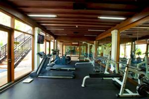 Fitnesscenter im Aonang Villa Resort mit Laufbändern, Hanteln und Spiegeln.