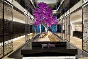 Innenbereich des Aonang Villa Resorts mit einem großen blühenden Baum.