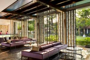 Empfangshalle des Aonang Villa Resorts mit violetten Sofas und modernen Metallschirmen.