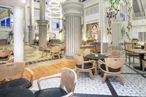 Interieur des Chada Thai Village Resorts mit Säulen, Tischen und Stühlen.