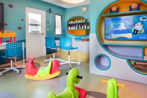 Das Kinderzimmer im ShellSea Krabi Hotel mit bunten Farben, Spielzeug und Fernseher.