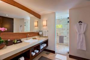 Ein Badezimmer mit einem großen Spiegel, einer Dusche und einem Waschbecken im El Mangroove, Autograph Collection Hotel.