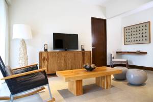 Wohnzimmer im El Mangroove, Autograph Collection mit Fernseher, Couchtisch und Sessel.