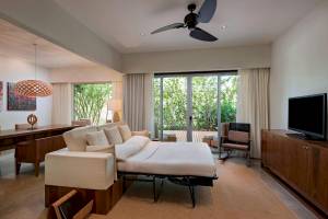 Hotelzimmer mit Sofabett, Esstisch, Fernseher und Gartenaussicht