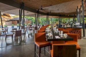 Innenbereich des El Mangroove, Autograph Collection Hotels mit Tisch, Stühlen und Bar.