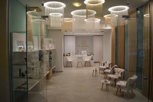 Innenbereich des Aegeon Spa mit modernen Möbeln, Glaswänden und runden Kronleuchtern.