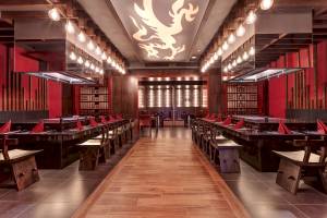 Innenansicht des Restaurants im Planet Hollywood Beach Resort mit roten Wänden, hölzernem Boden und langen Tischen.