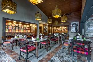 Innenansicht des Restaurants im Planet Hollywood Beach Resort mit farbenfrohen Sitzmöbeln, Holzdecken und kunstvollen Lampen.