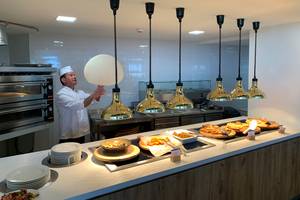 Buffet-Tisch mit verschiedenen Speisen und goldenen Lampen im Hotel Creta Princess Aquapark & Spa.