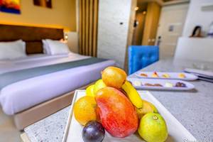 Hotelzimmer des Titanic Royal mit einem Bett und einer Obstplatte auf dem Tisch.
