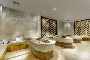 Spa-Behandlungsraum im Titanic Royal Hotel mit Marmorwänden und goldenen Akzenten.
