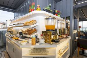 Frühstücksbuffet im Arden City Hotel mit Brot, Cerealien, Früchten und Getränken.