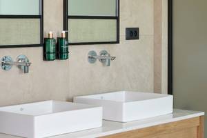 Ein Badezimmer mit zwei weißen Waschbecken und Marmorboden im Melia Durres Hotel in Albanien.